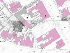 An extract from a map showing buildings on either side of a road. Some of the buildings have been coloured pink and others have been coloured grey.