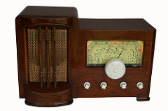 An old-fashioned radio with a dark brown varnished case, a speaker to the left, and a dial to the right.