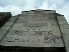A stone façade with “1926” embossed at the top and “Out Patients Department” below.