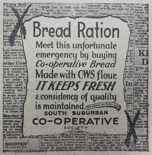 Advert with the following text on a faux-background of newsprint: “Bread Ration / Meet this unfortunate emergency by buying Co-operative Bread / Made with CWS flour, it keeps fresh & consistency of quality is maintained.  Dividend on every loaf.  South Suburban Co-operative Society”.