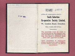A small opened book with the printed name and address of the South Suburban Co‑operative Society Limited at 99 London Road, Croydon.  Below, it states: “The payments must be made in full punctually as they become due, and members are requested to see that they obtain a dividend check when each payment is made.  Upon completion of payments please forward this book to Office, London Road, Croydon, for official cancellation.”  Two dates have been stamped opposite: “5 Oct 1949” and “6 Sep 1951”.