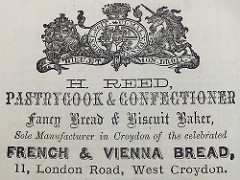 A black-and-white printed advert with a rather squashed version of the United Kingdom royal coat of arms at the top and wording below in six different fonts: “H. Reed, Pastrycook & Confectioner / Fancy Bread & Biscuit Baker, Sole Manufacturer in Croydon of the celebrated French & Vienna Bread, 11, London Road, West Croydon.”