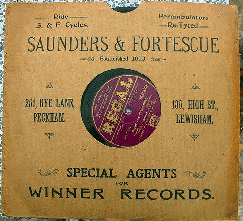 A light brown record sleeve with text reading: “Ride S. & F. Cycles.  Perambulators Re Tyred.  Saunders & Fortescue / Established 1900.  251, Rye Lane, Peckham.  135, High St., Lewisham. Special Agents for Winner Records.”