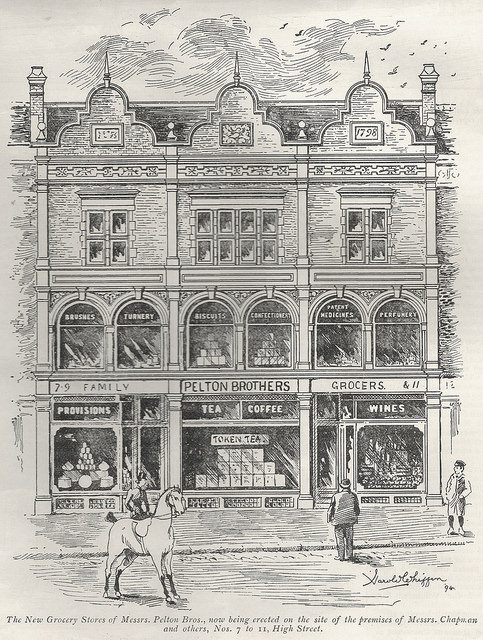 Drawing of a three-storey, three-shopfront building with “1798” on a plaque at the top and signs in the windows underneath advertising brushes, turnery, biscuits, confectionery, patent medicines, perfumery, provisions, tea, coffee, and wines.