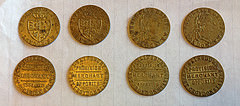Eight brass “spade guineas” showing different sides and a total of four designs.  The text on the backs reads “J. Sainsbury.  Provision merchant opposite West Croydon Station.”