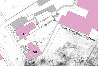 An extract from a map showing buildings on one side of a road. Some of the buildings have been coloured pink and others have been coloured grey.
