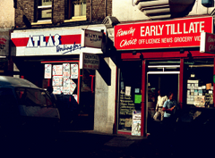 Two terraced shopfronts; the left-hand one is Atlas and the right-hand one is a convenience store called Early Till Late.