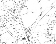 A black-and-white map showing several numbered plots along the sides of roads and a railway line.  Most of the land has not yet been built on.