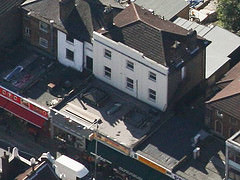 An oblique view from above, showing a three-story house with a long forwards extension on the ground floor at the front.