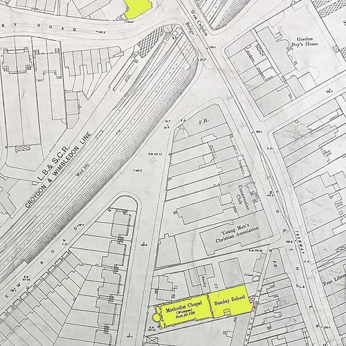 A detailed map showing the same area as the previous image.  The yellow-highlighted building has been extended to the west.